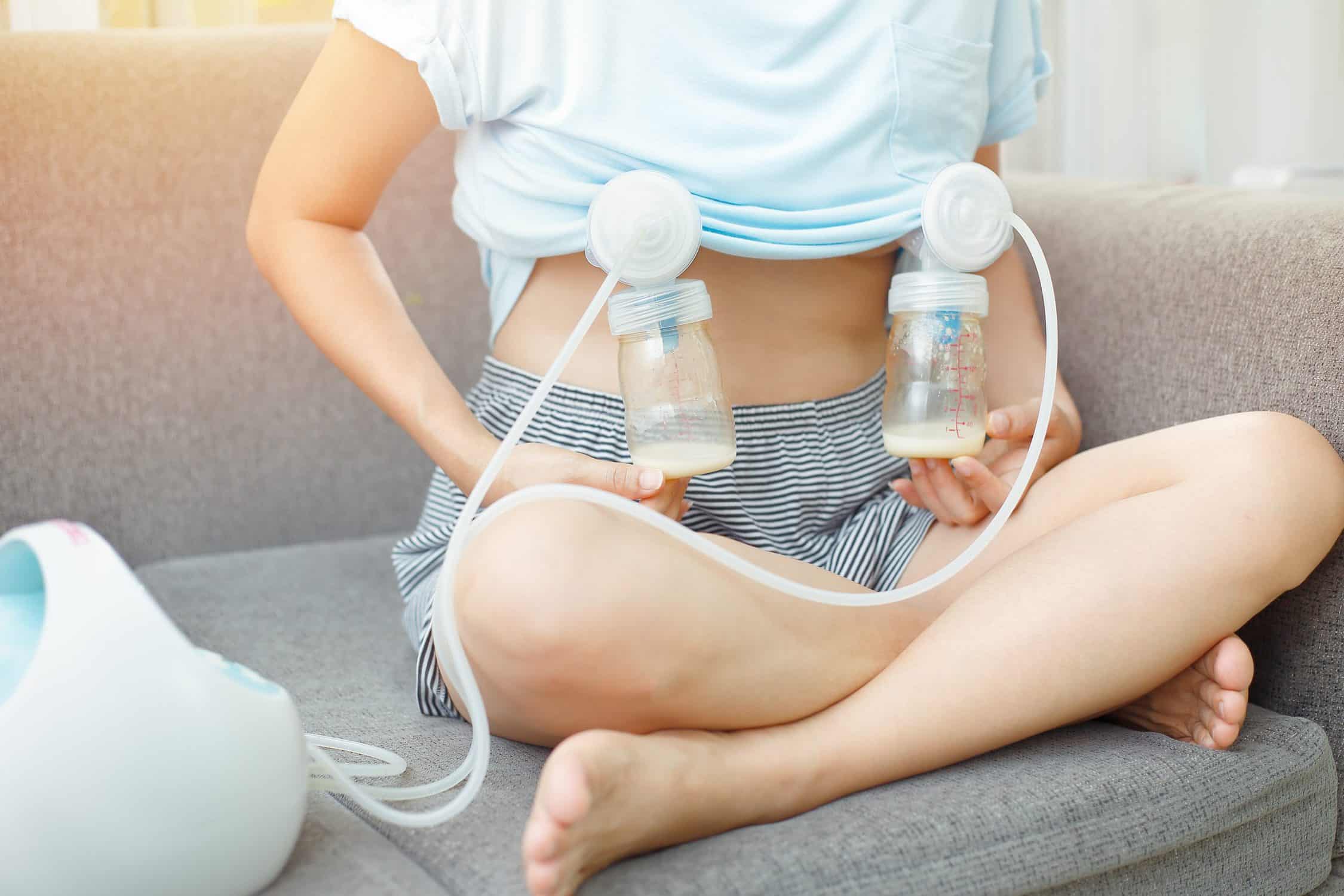 Asian mom use electric breast pump feeding   for her baby.
