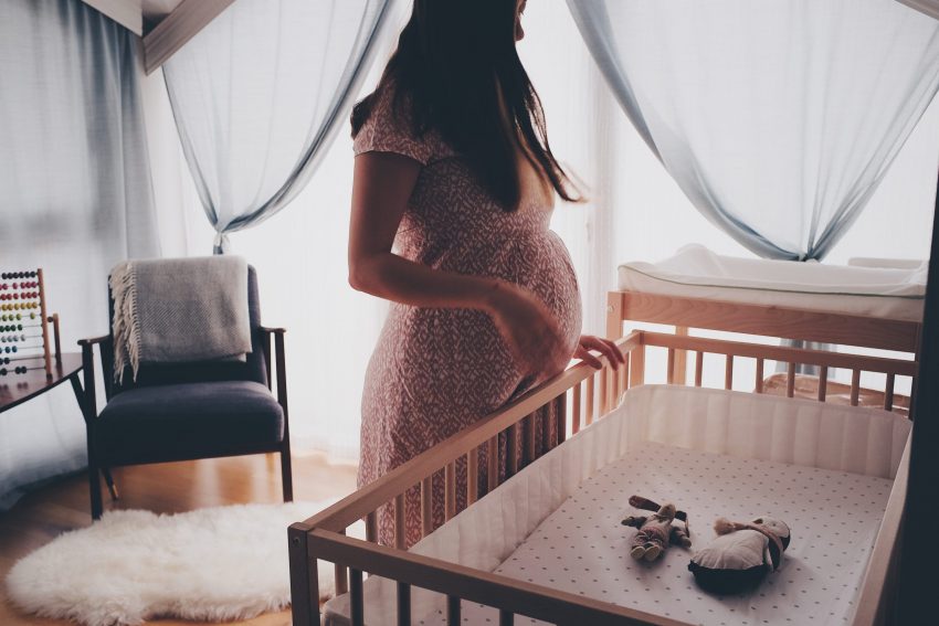 pregnant woman near crib