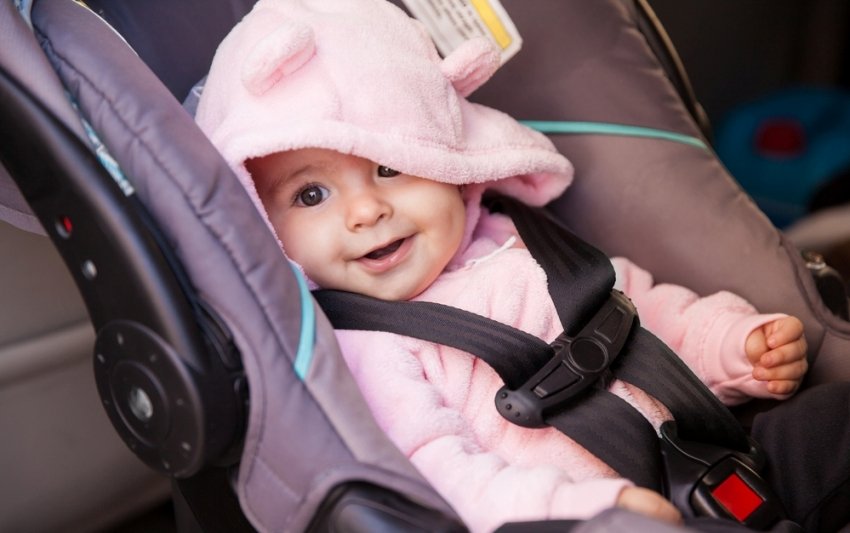 Happy baby girl in a car seat
