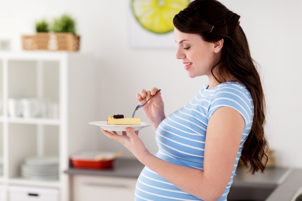 pregnant woman eating cake