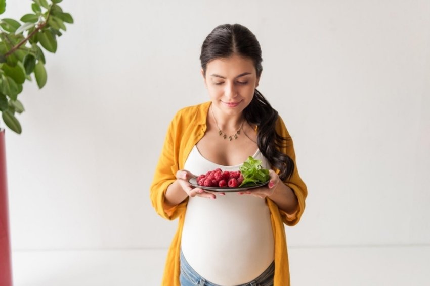 pregnant woman smelling her food