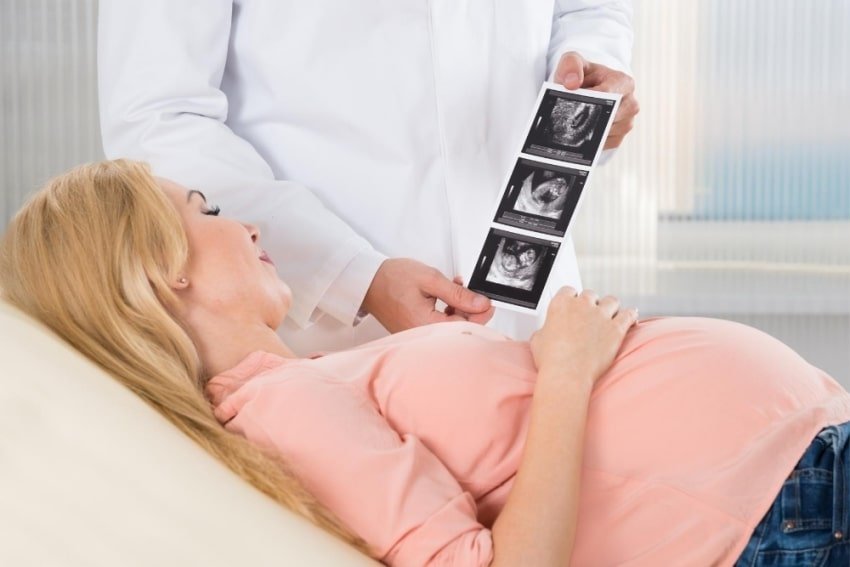 pregnant woman looking at womb
