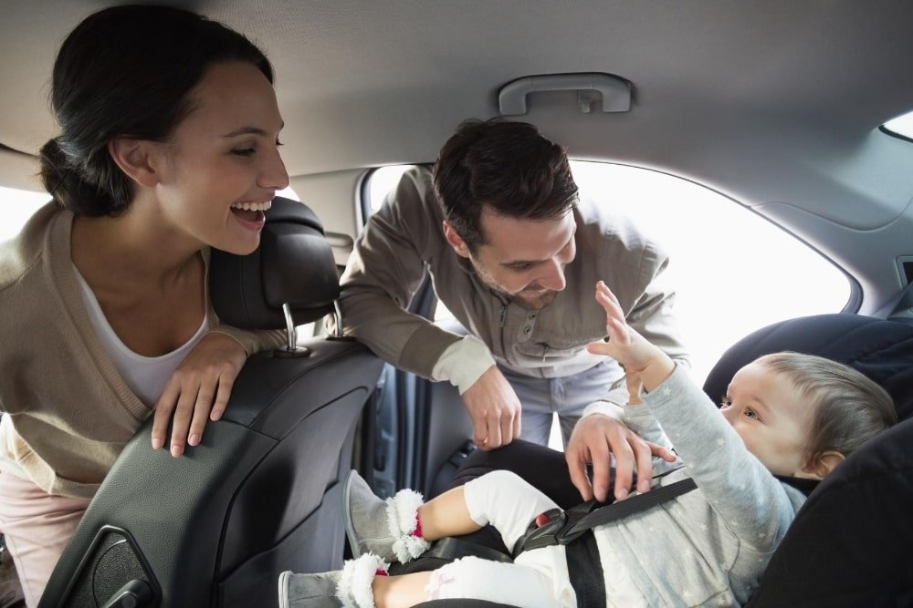 parents and baby in a car