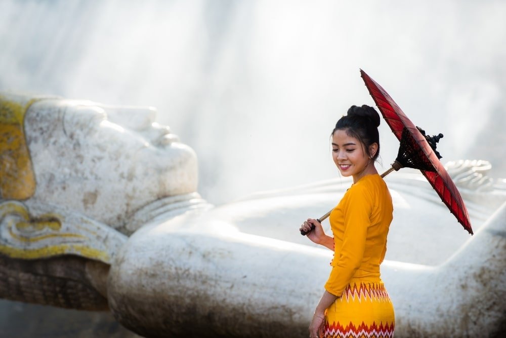 a girl near a Buddha statue