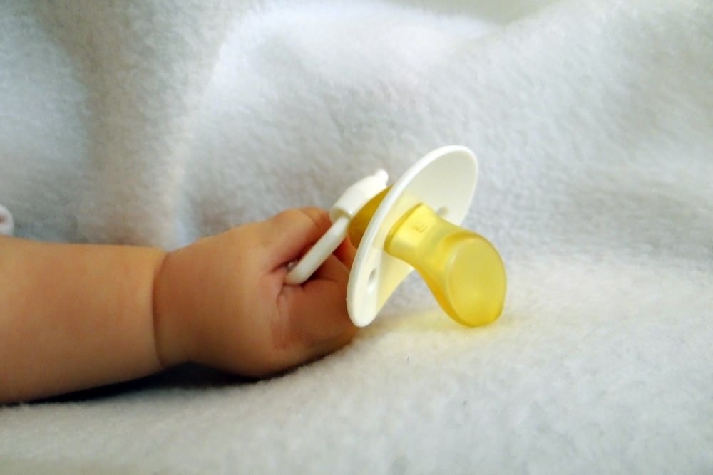 baby hand holding a pacifier