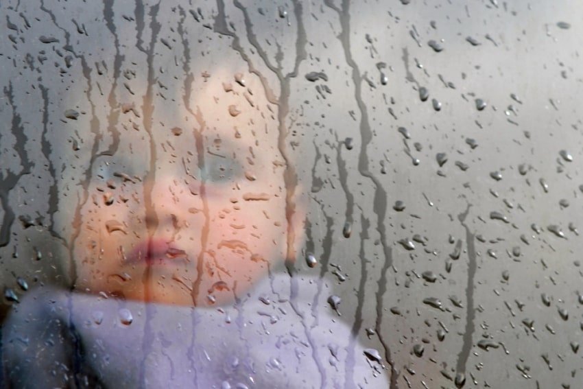 baby reflected through a window in a rain