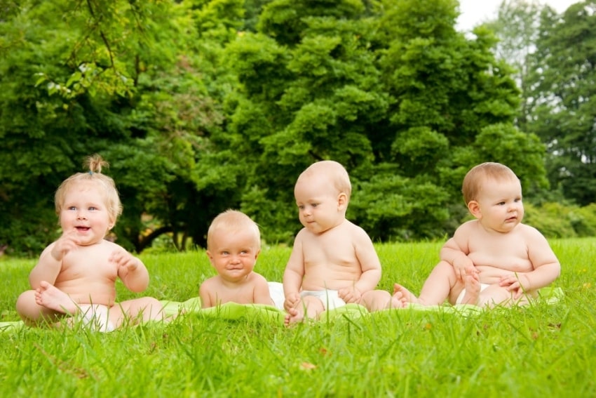 four babies on a grass