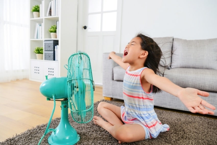 girl in front of an electric fan
