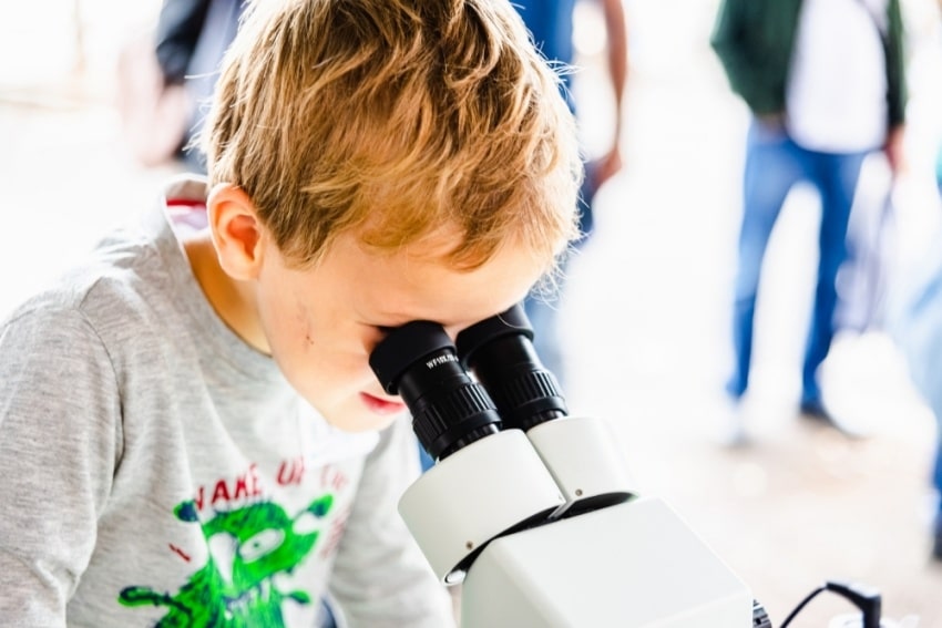 kid looking at microscope