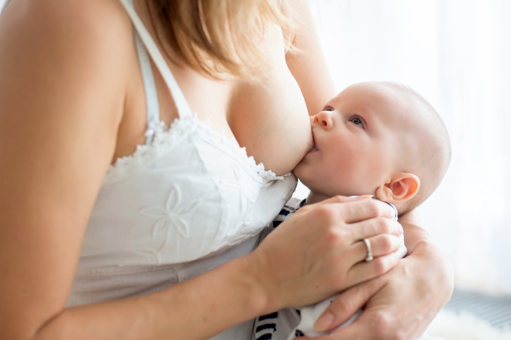 Young mother breastfeeding her newborn baby boy