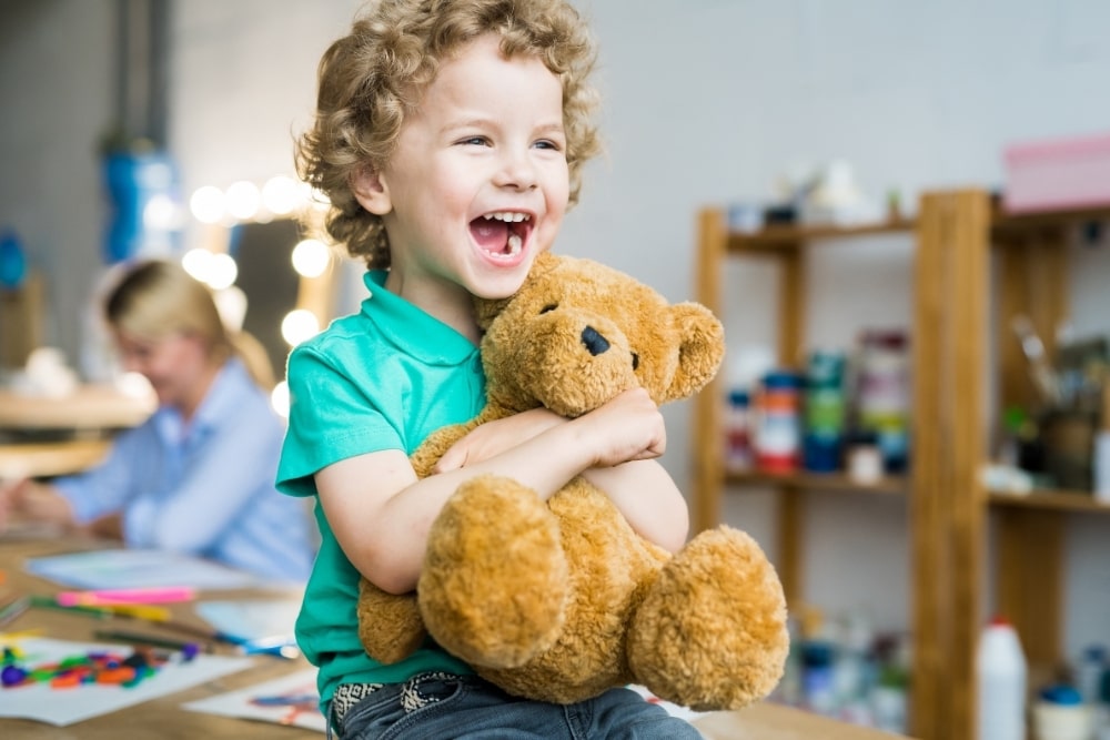 happy kid holding a teddy bear