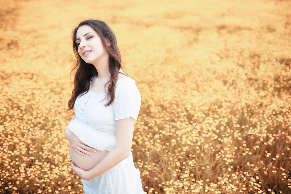 pregnant standing on a field