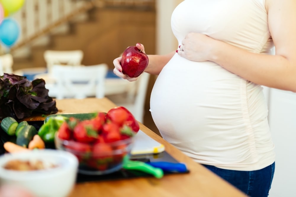 pregnant woman near healthy food