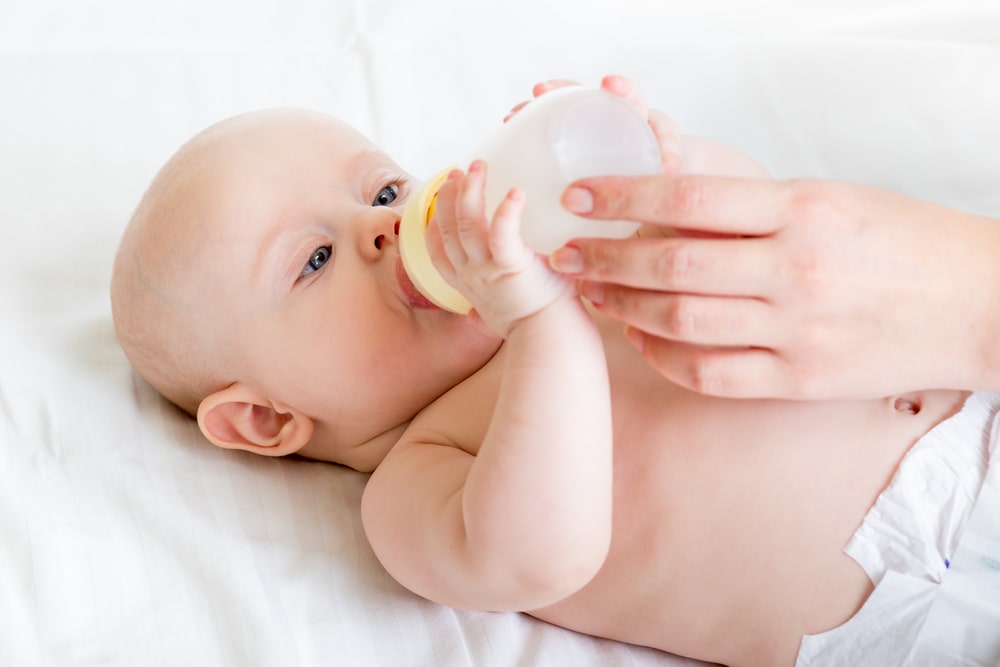Baby infant eating milk from bottle