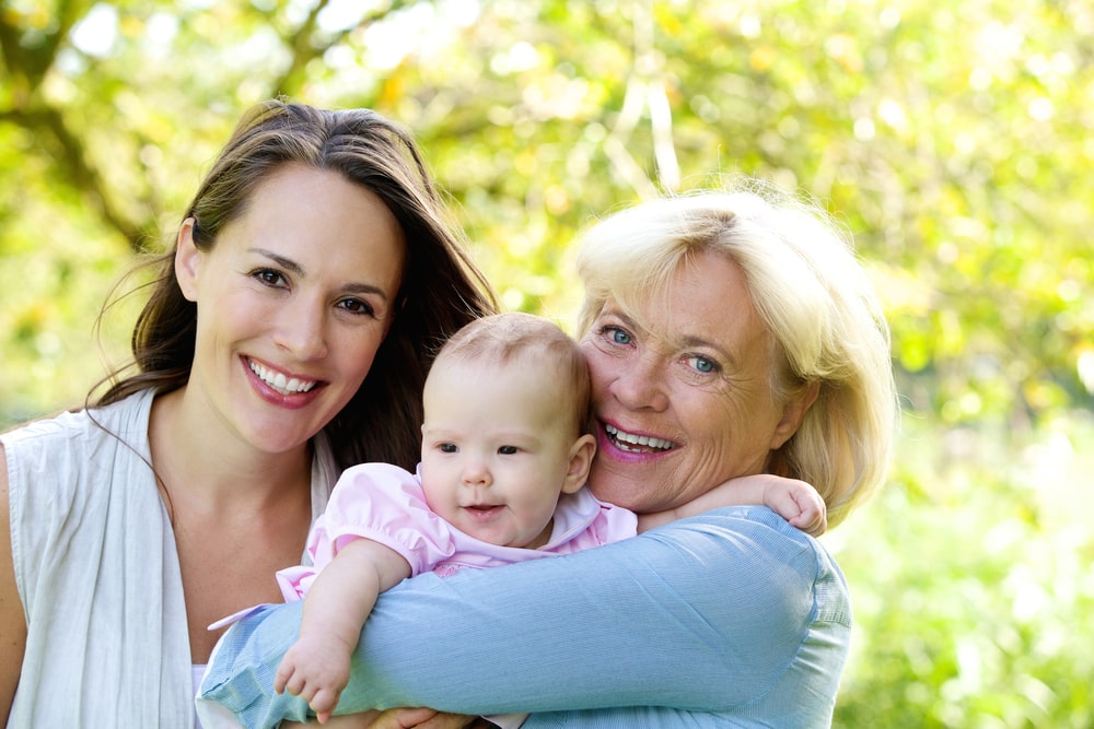 Grandmother and mother smiling with baby