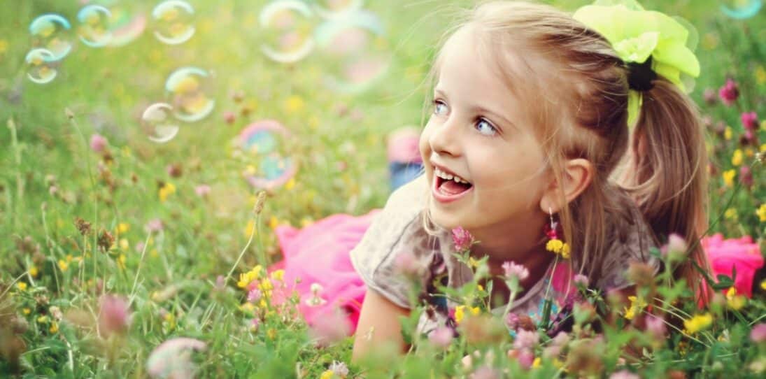 Happy little girl playing with bubbles