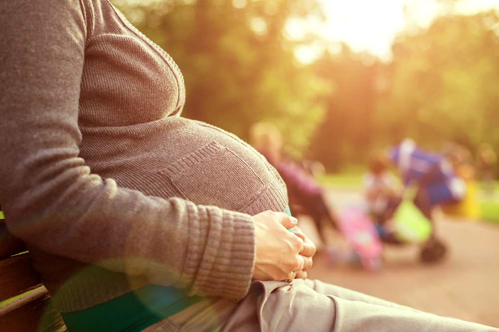 Pregnant woman sitting on a bench-