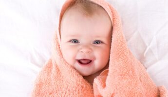 cute baby wrapped in an orange towel