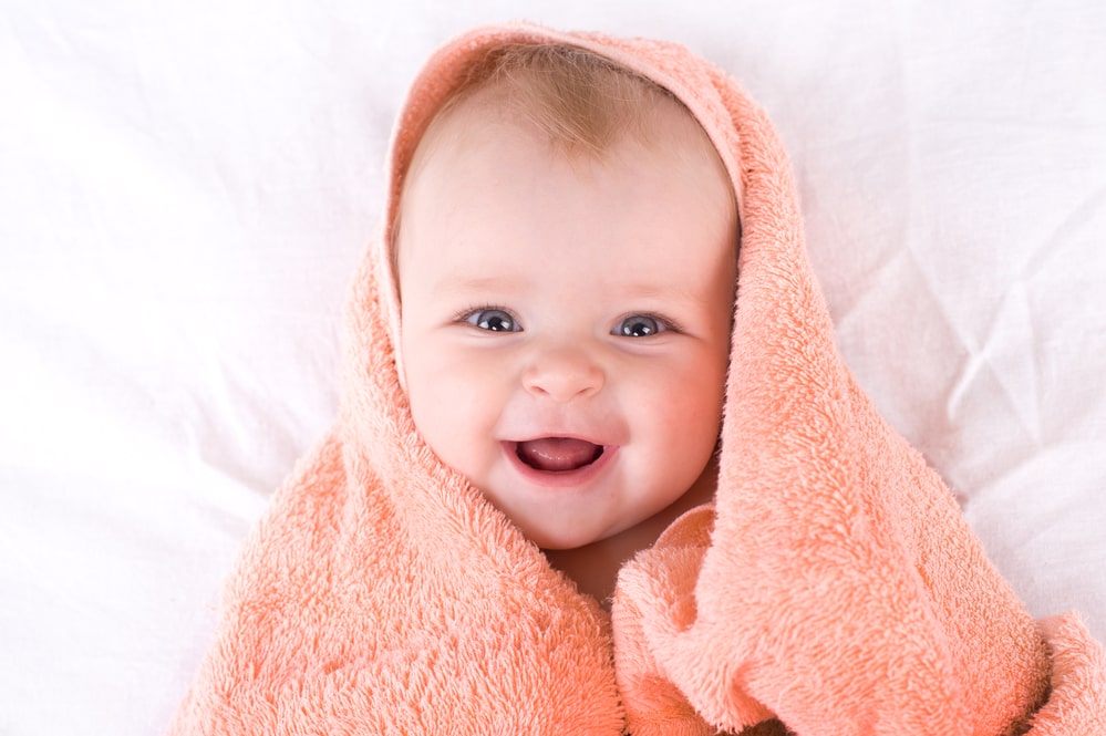 cute baby wrapped in an orange towel