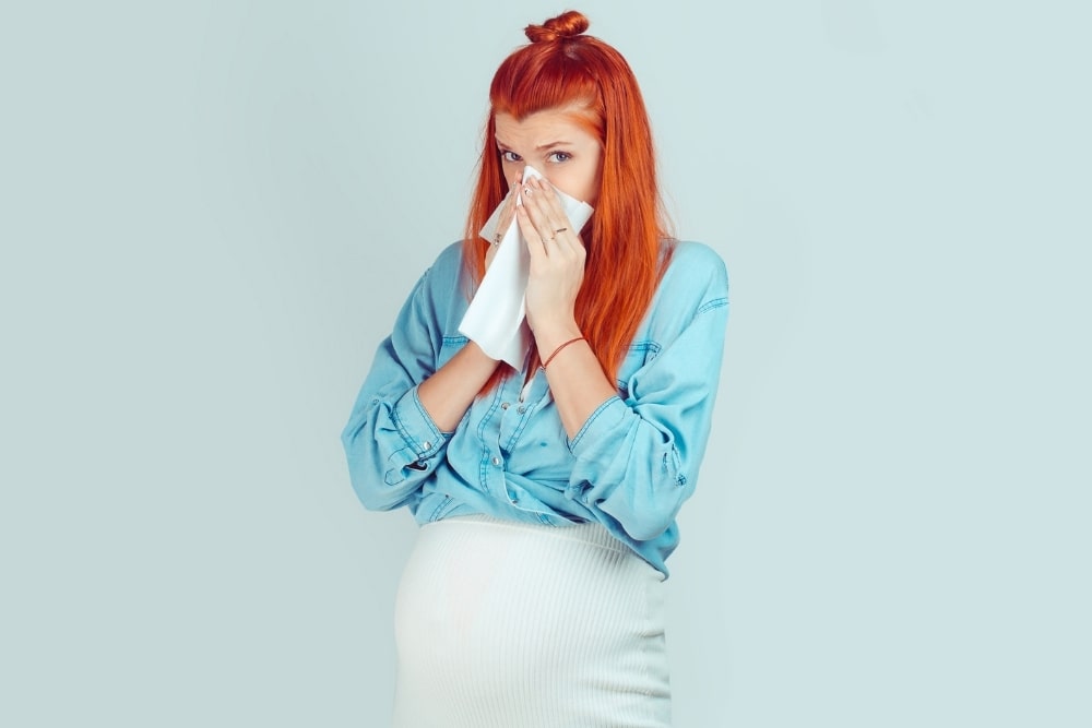 pregnant blowing her nose sick