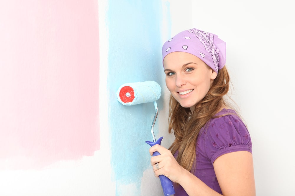 Early pregnant woman deciding to paint nursery pink or blue