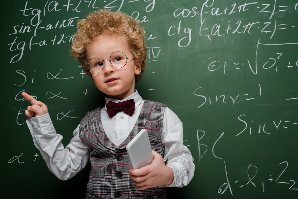 Smart child in suit and bow tie holding smartphone