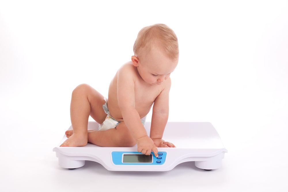 Baby boy check own weight on scales