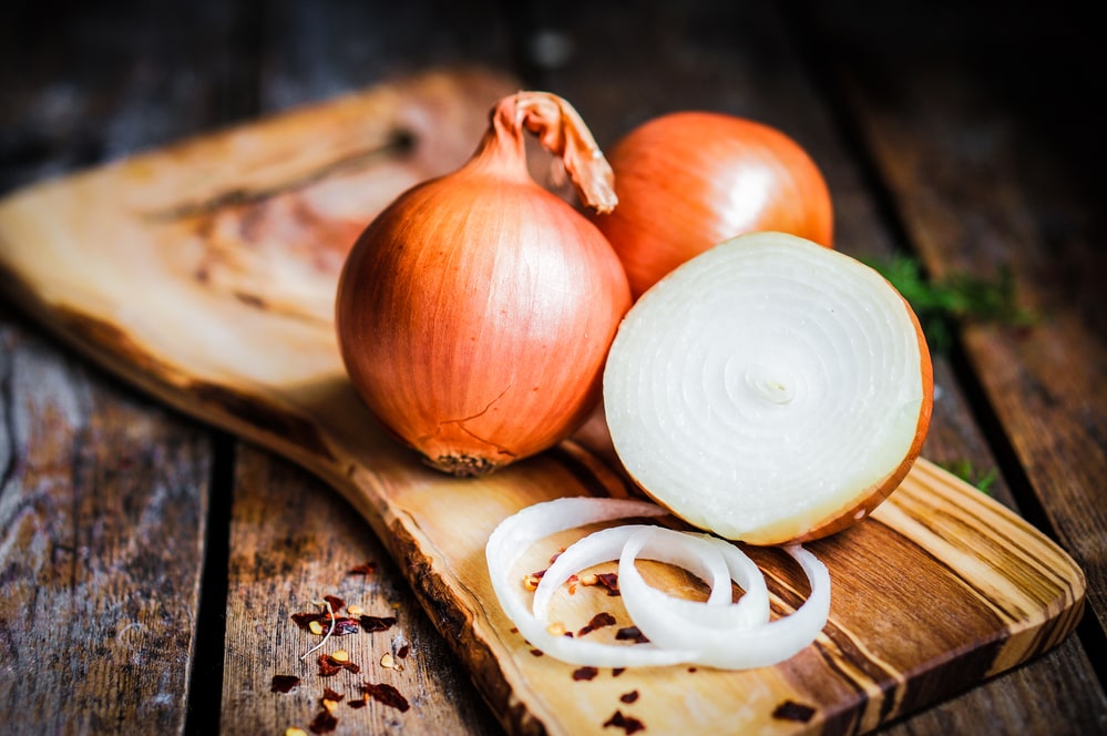Colorful onions and garlic on rustic wooden background