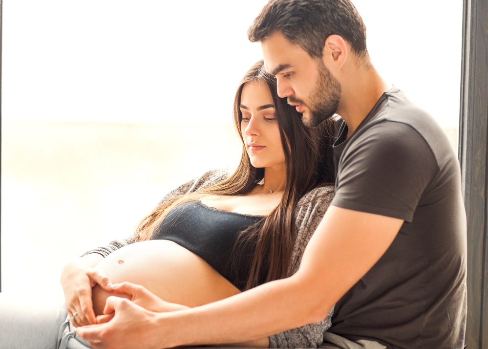Couple in love pregnant cuddling, waiting for baby