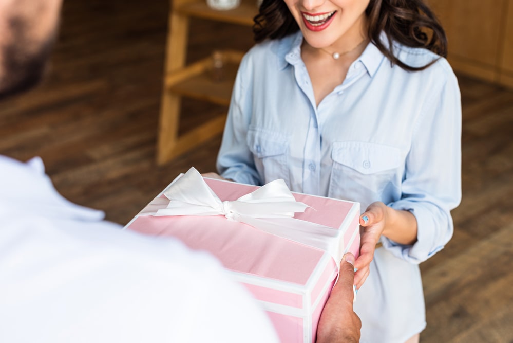 Cropped view of happy woman receiving present from delivery