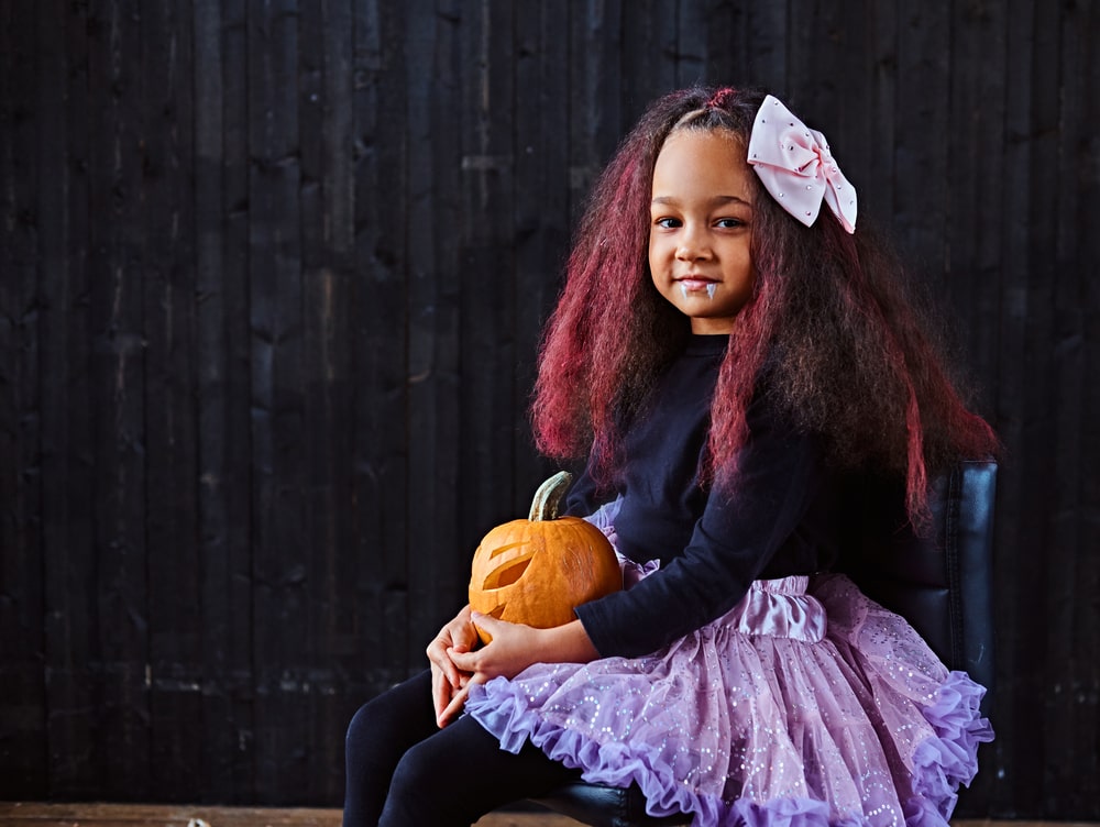 Dark-skinned little girl dressed in trendy scary dress