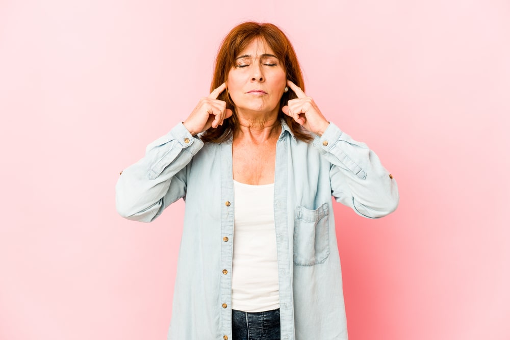 Senior caucasian woman isolated covering ears