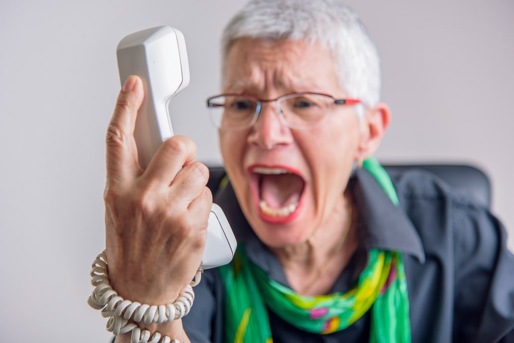 Terrible service, angry senior woman yelling at phone