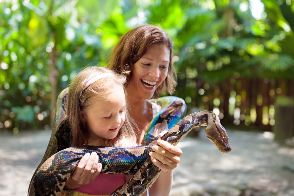 mom and girl hold snake