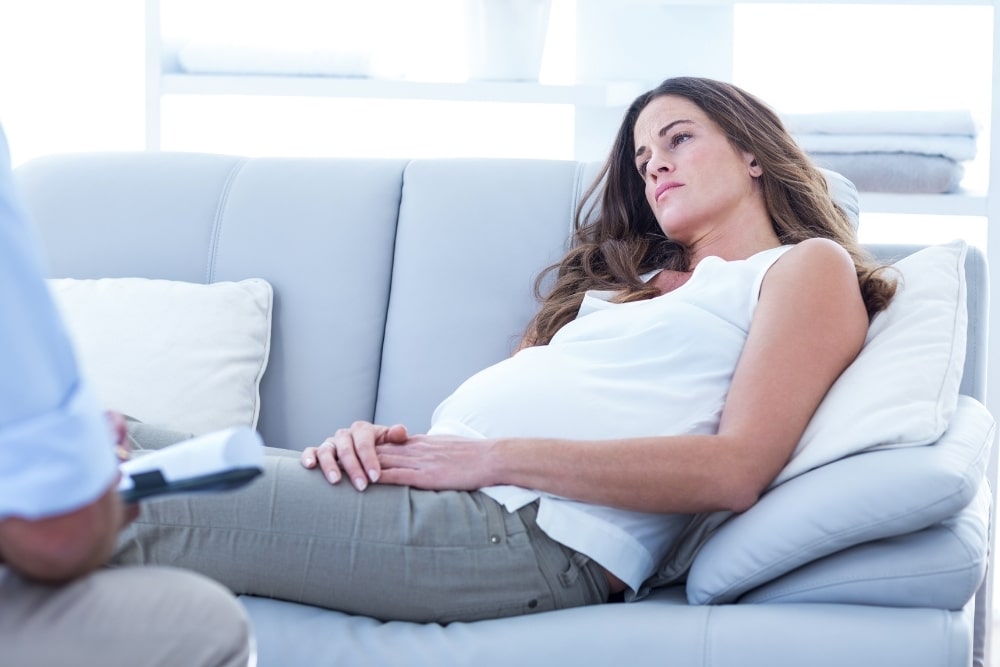woman alone pregnant on couch