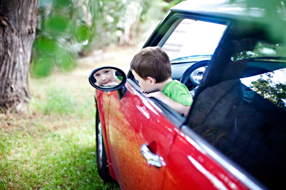 little boy outdoors car mirror