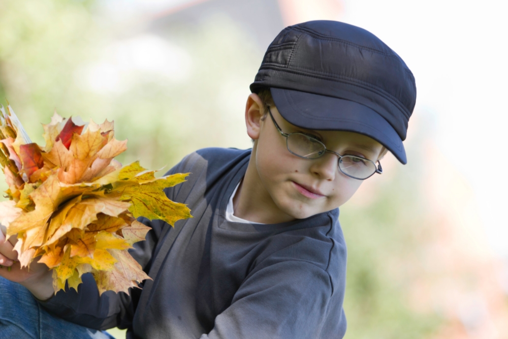 little boy outdoors wearing glasses
