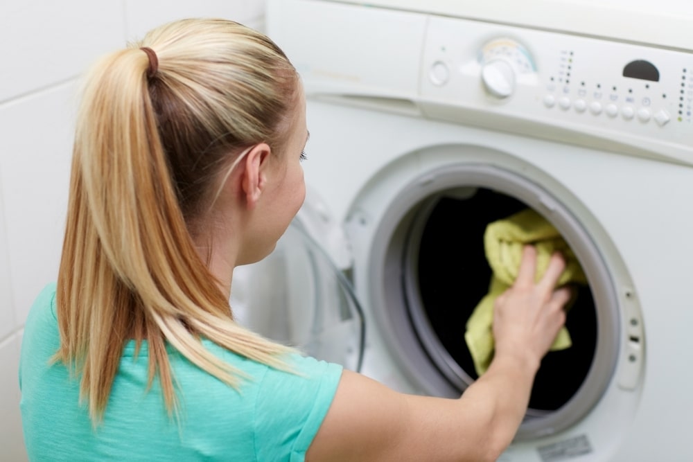 woman doing laundry in front of washing machine