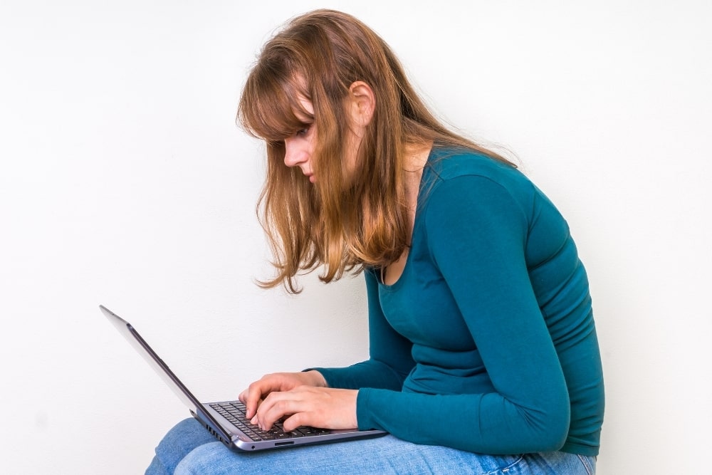 woman slouching sitting using laptop
