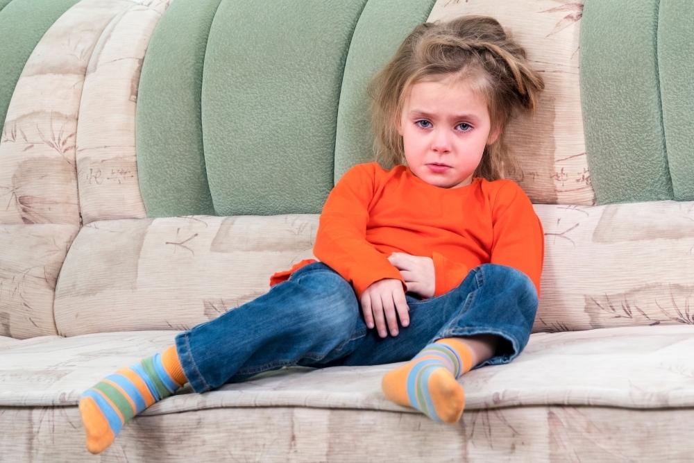 little girl crying in couch